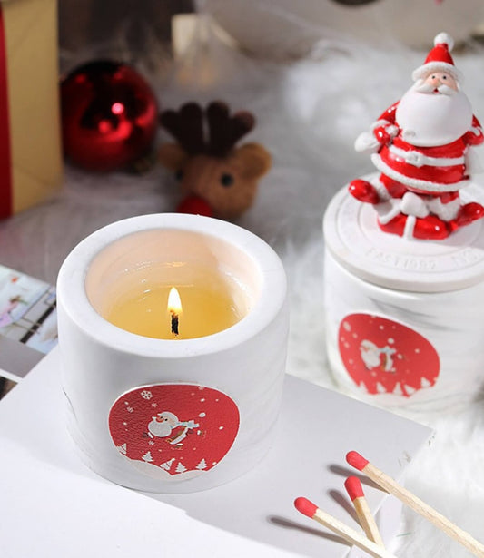 Another Santa Claus scented candle, holding a gift and smiling.