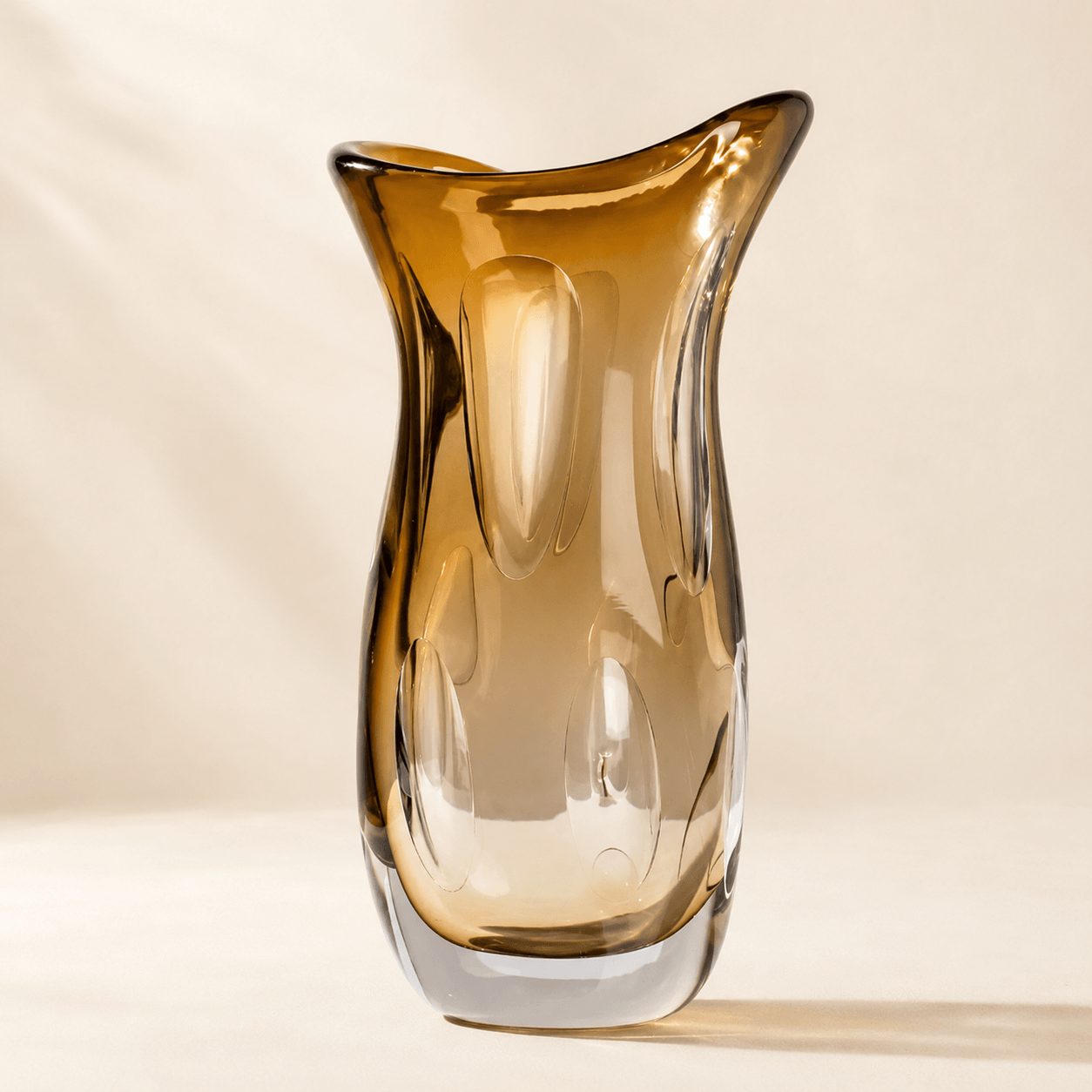 Large amber sculptural art glass vase with a wide asymmetric rim and raised inner petal details