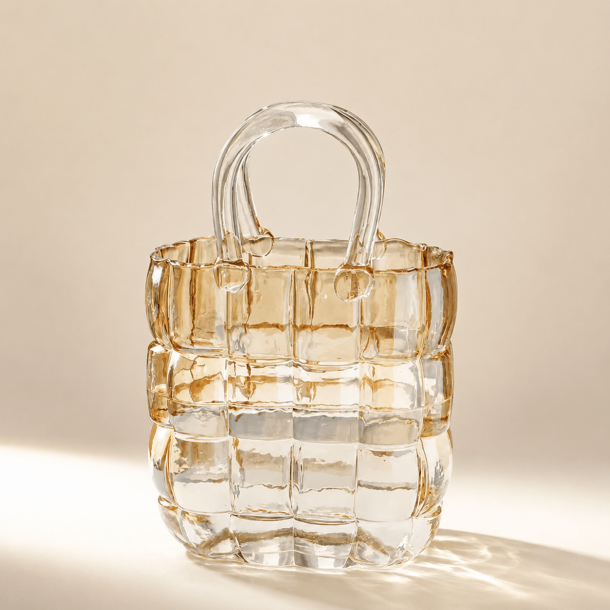 Warm clear basket-weave glass handbag vase on a softly lit neutral background