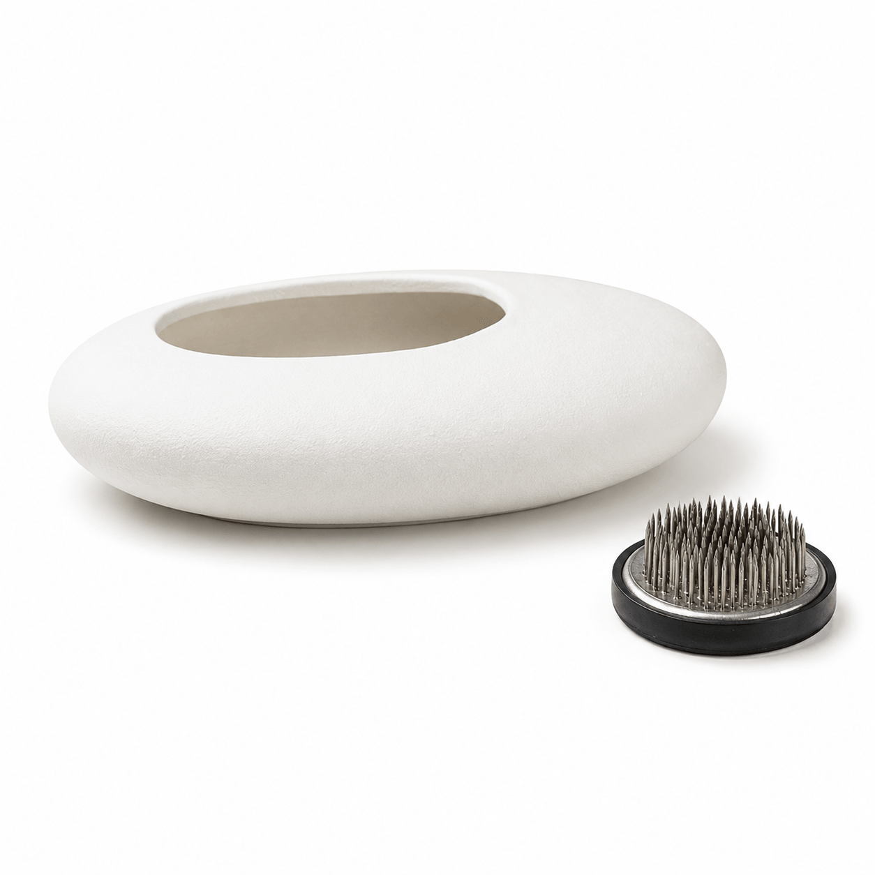 White oval ceramic flower bowl with 46 mm kenzan on a white background.