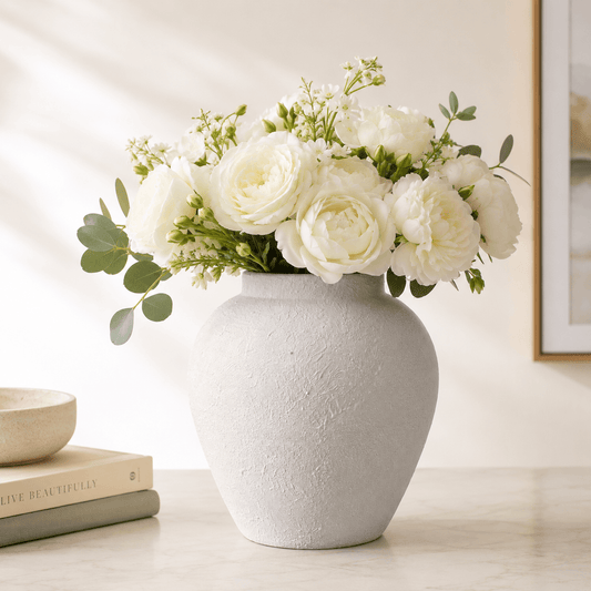 White textured ceramic vase styled with a full white flower bouquet.