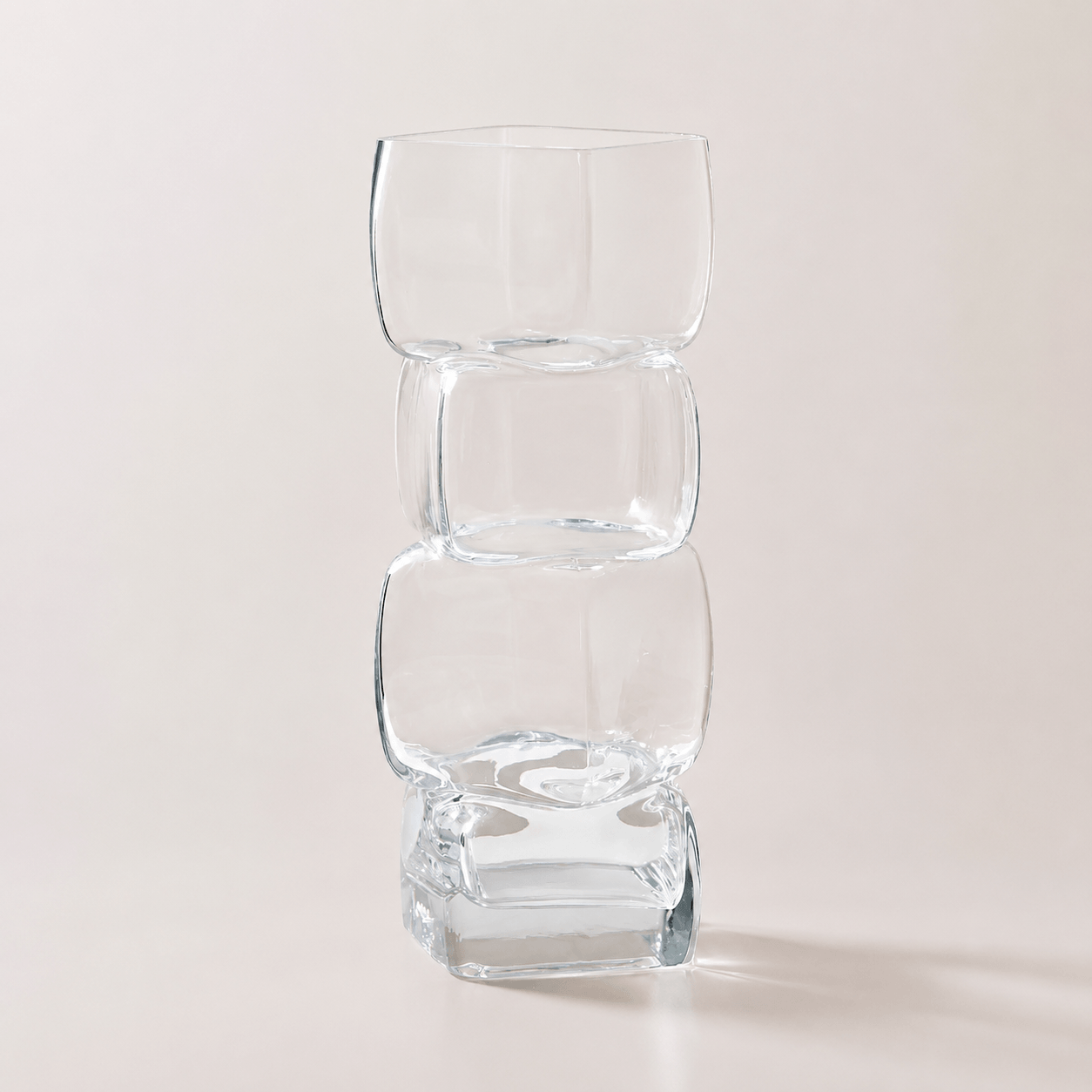 Crystal clear sculptural hand-blown glass vase with stacked geometric form on a clean neutral background.