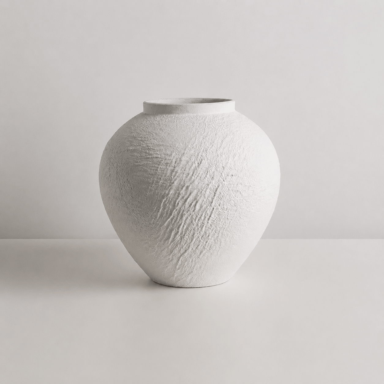Small round white textured decorative vase without flowers
