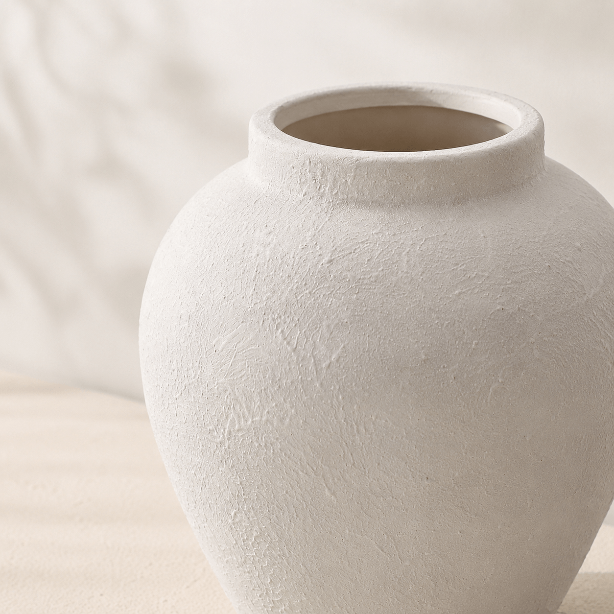 Close-up of the textured surface and wide opening of the white ceramic vase.