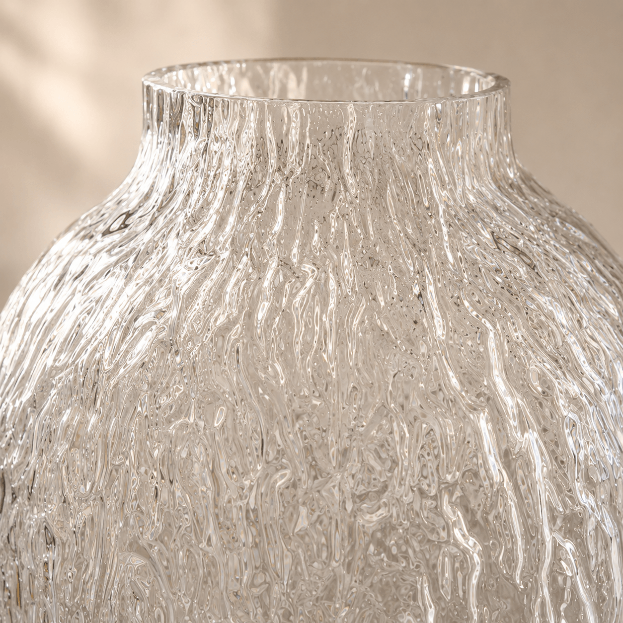 Close detail of the clear glass vase showing its irregular vertical rippled texture and short neck