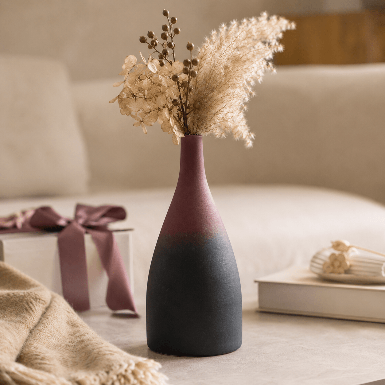 Tall gradient ceramic vase with dried flowers in a warm home decor setting

