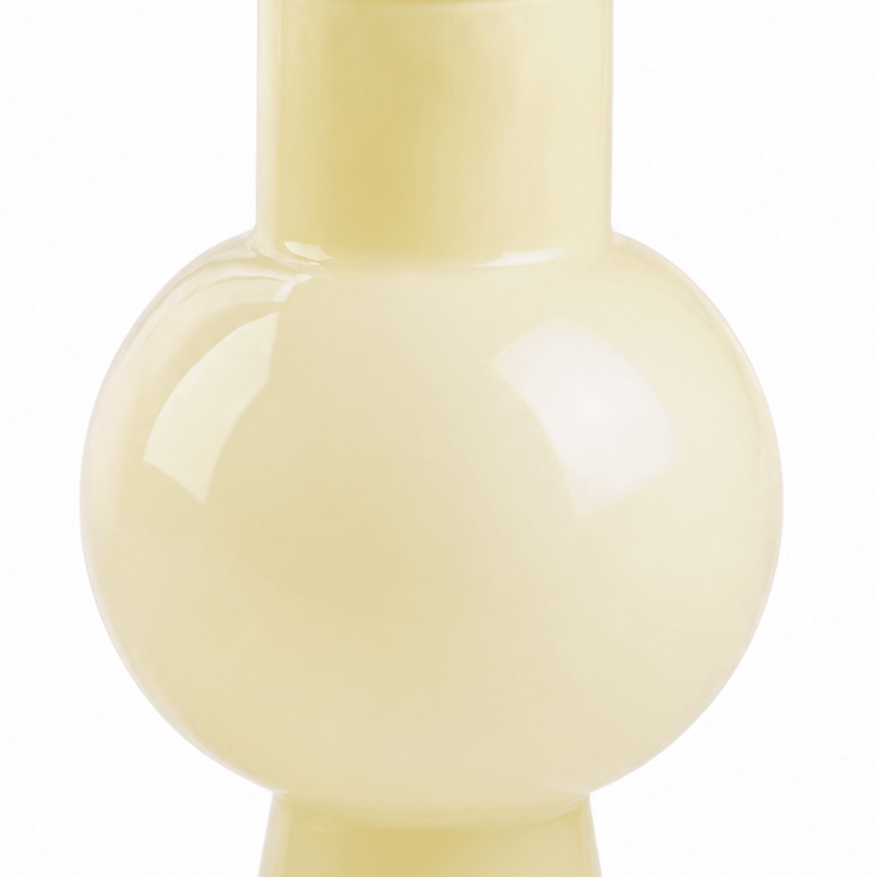 Close-up of the smooth semi-translucent ivory glass and rounded vase shoulder