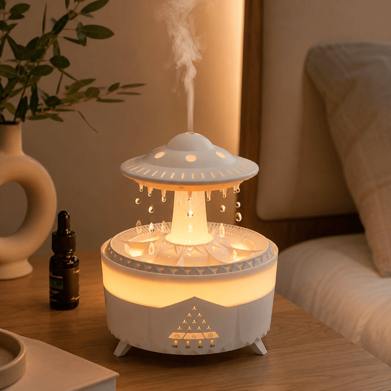 White raindrop diffuser on a bedside table with essential oil and warm light