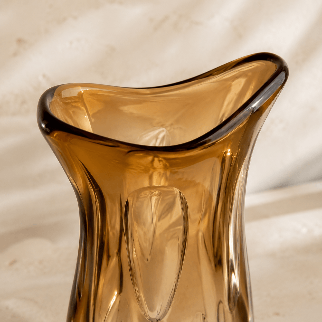 Close-up of the wide asymmetric rim on a large amber art glass vase