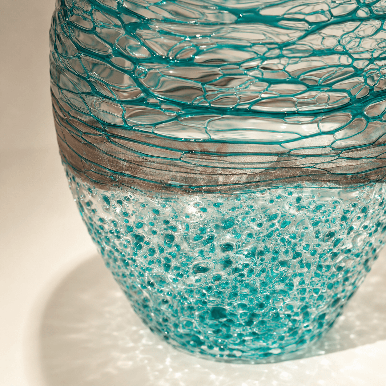Close-up of layered turquoise thread-like texture on an art glass vase