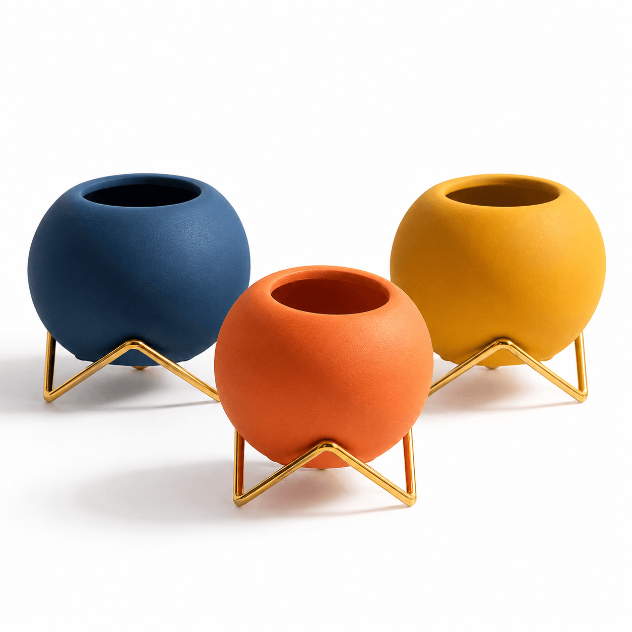 Blue orange and yellow round vases with gold stands isolated on a white background
