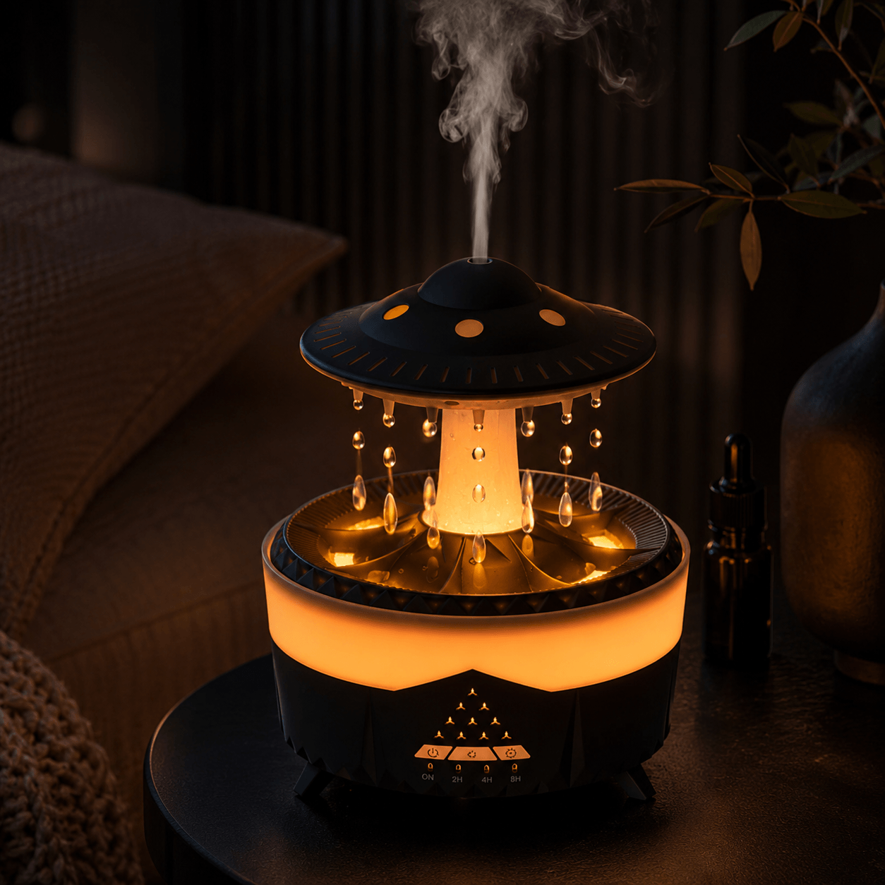Black UFO raindrop diffuser on a nightstand with warm light, droplets, and mist