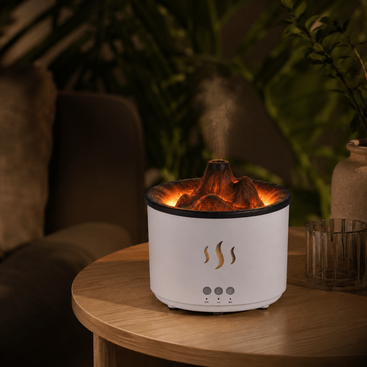 White volcano aroma diffuser with black mountain top on a wood side table with soft mist.