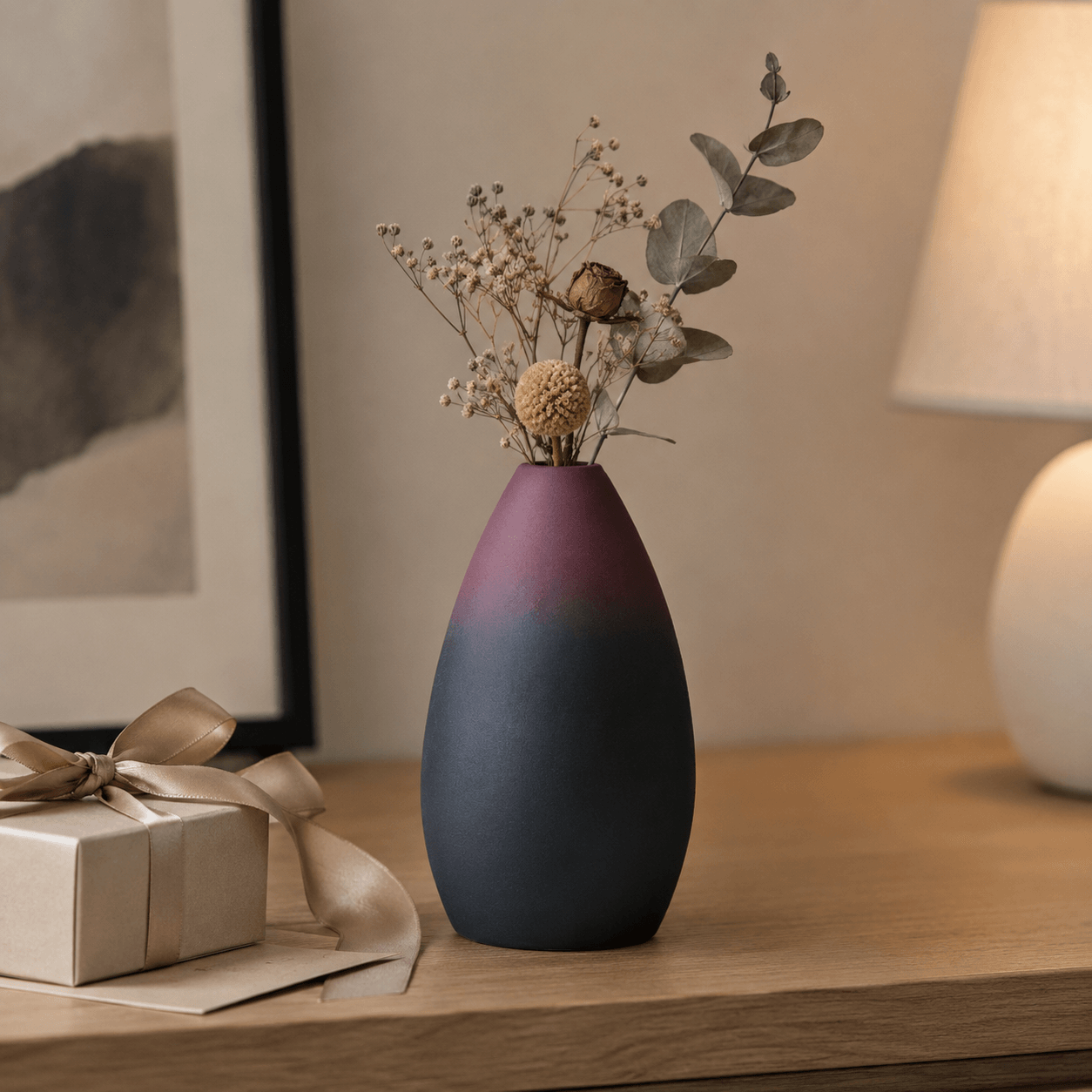Rounded gradient ceramic vase with dried flowers in a warm bedside decor scene