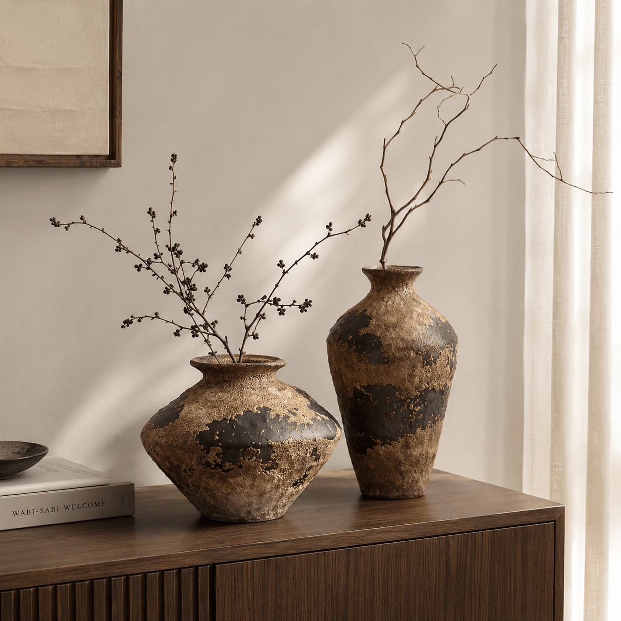Wabi-sabi ceramic vase pair styled on a wooden console table in warm natural light