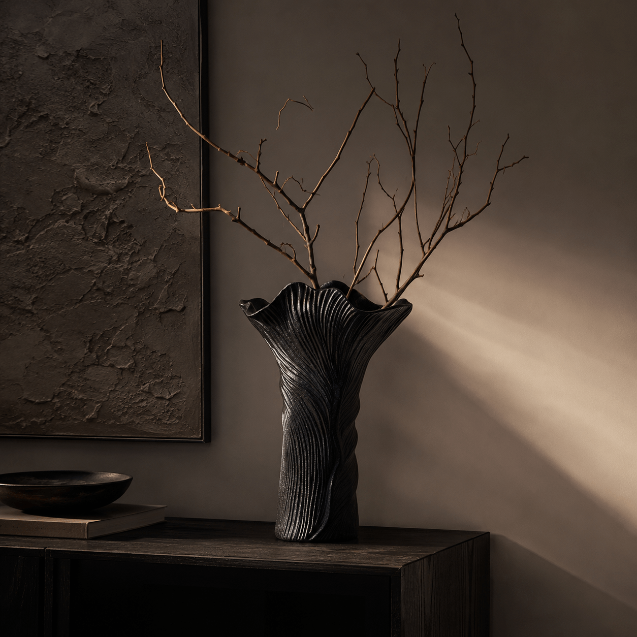 Black Flow Vase styled with bare branches on a dark console table