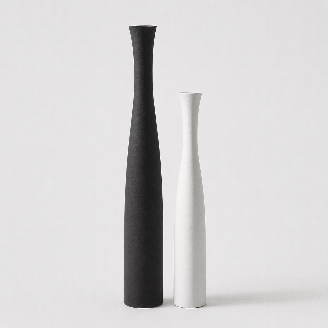 Mixed ceramic vase set with a large black vase and a small white vase for modern decorative styling.