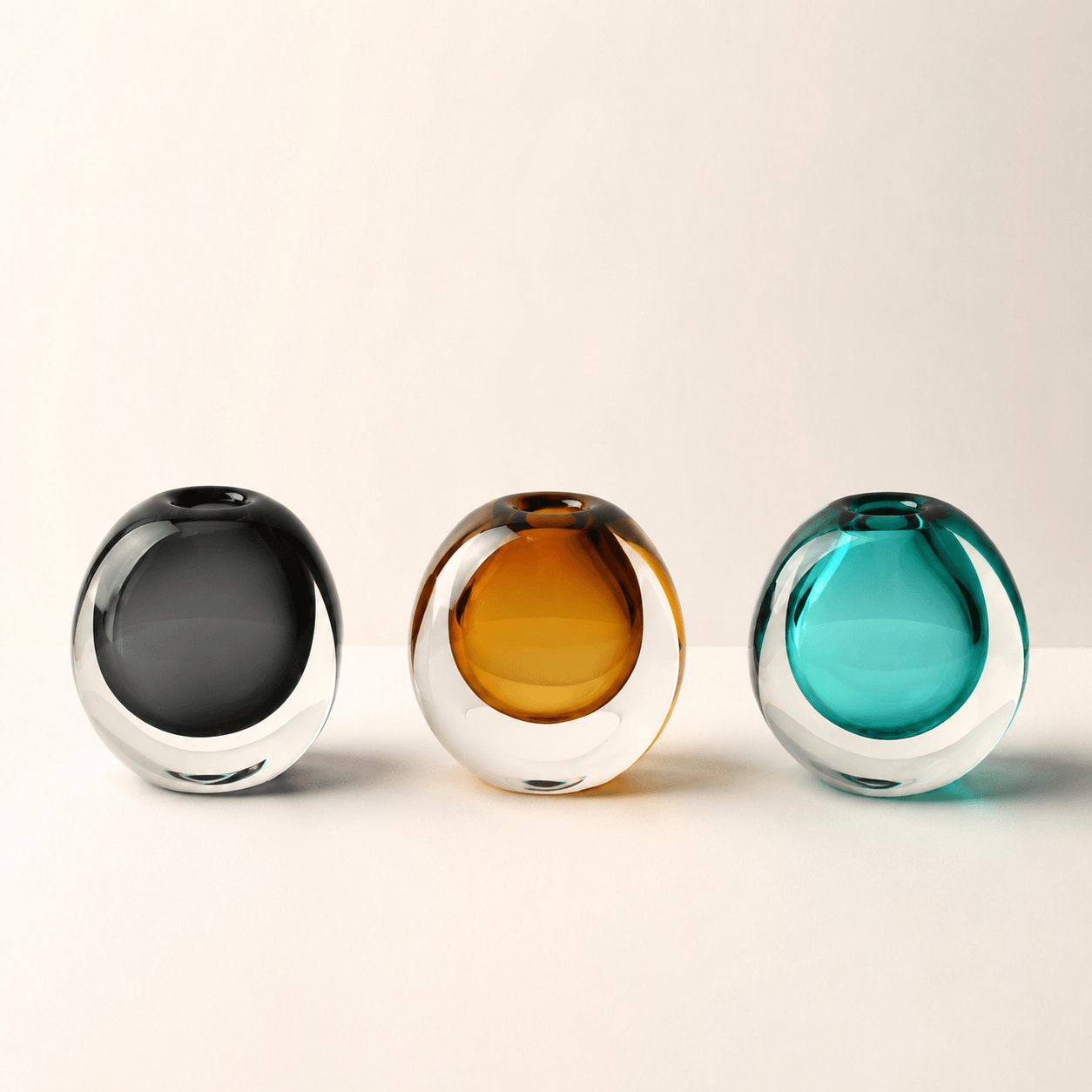 Dark Gray, Amber, and Peacock Blue color spectrum glass vases displayed together on a clean background.