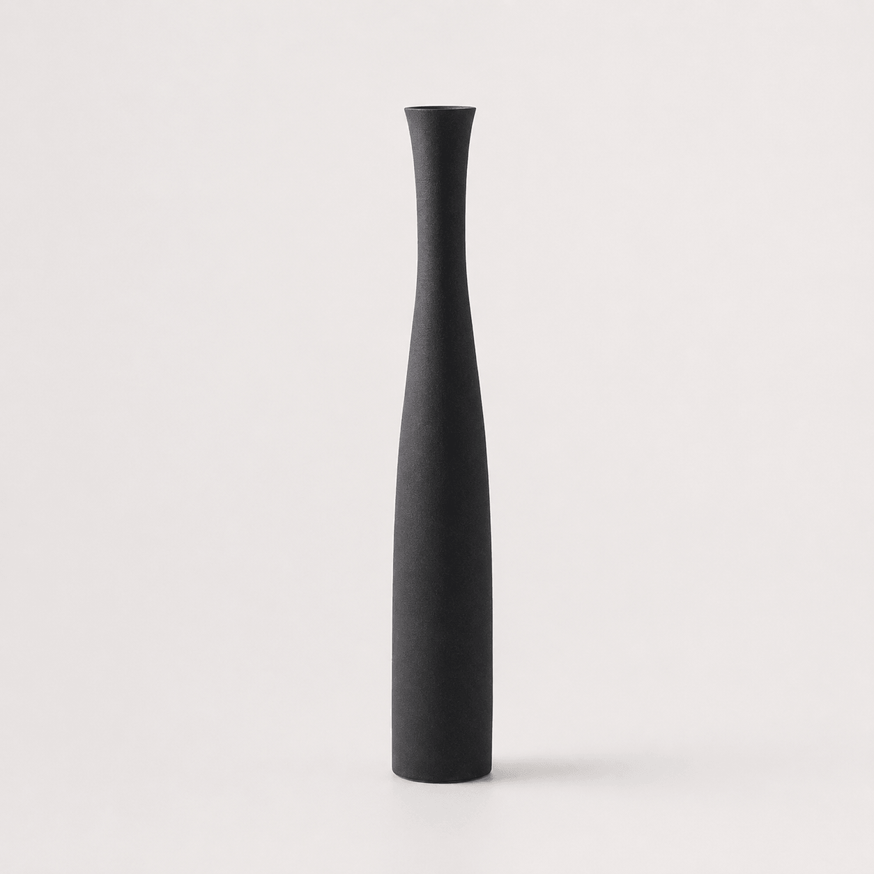 Small matte black ceramic vase with a slim sculptural silhouette for contemporary decor.