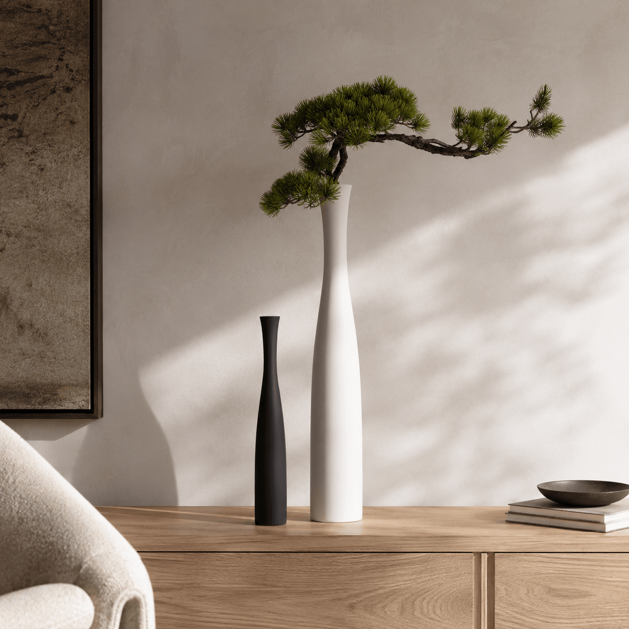 Large white and small black ceramic vases styled on a wood console with soft natural light.