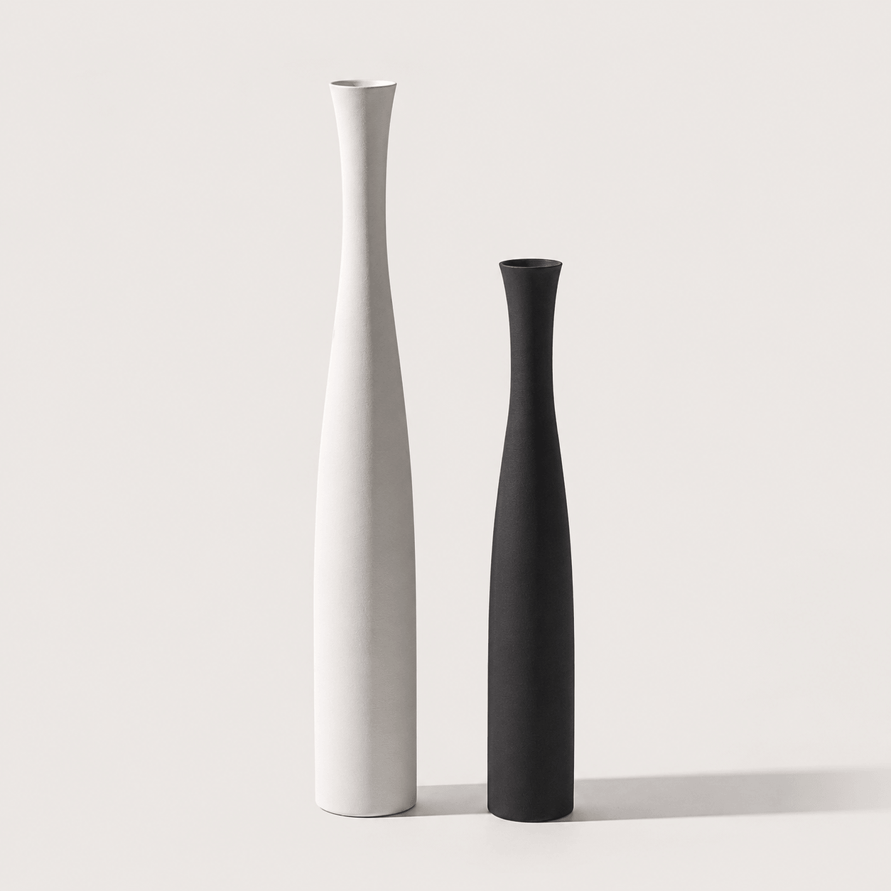 Mixed ceramic vase set with a large white vase and a small black vase for elegant interior decor.